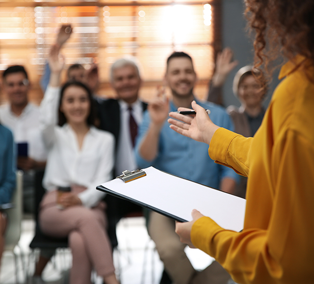 Businesswoman answering questions Businesswoman answering questions of guests in a room