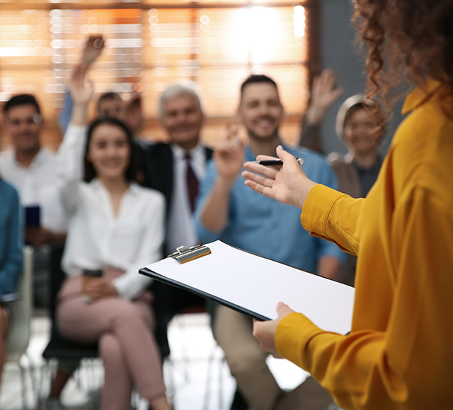 Businesswoman answering questions of guests in a room